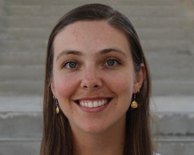 Picture of Sadie Woloson standing against a background featuriing a stair case